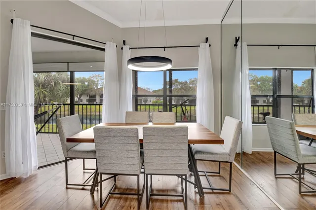 a view of a dining room with furniture wooden floor and floor to ceiling window