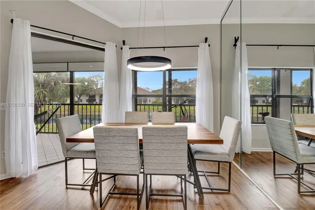 a view of a dining room with furniture wooden floor and floor to ceiling windows