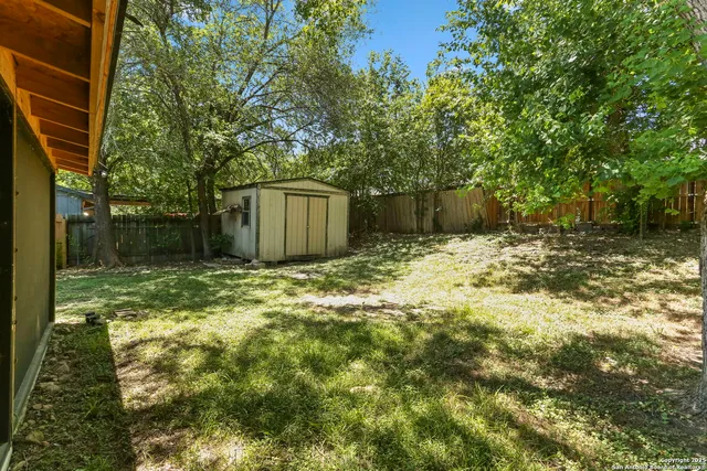 a backyard of a house with a large tree