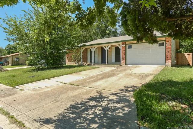a front view of a house with a yard and trees