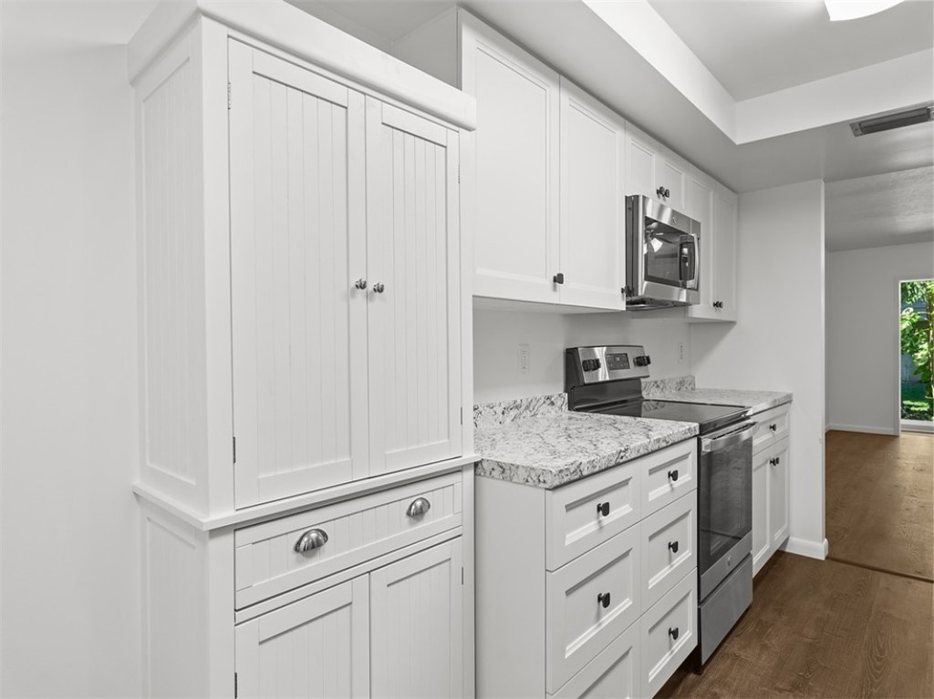 1166 6th Avenue, Unit C5 Vero Beach, FL 32960 - Photo 12 of 34 a kitchen with white cabinets and white appliances
