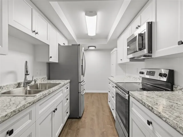 a kitchen with stainless steel appliances granite countertop a sink stove and refrigerator