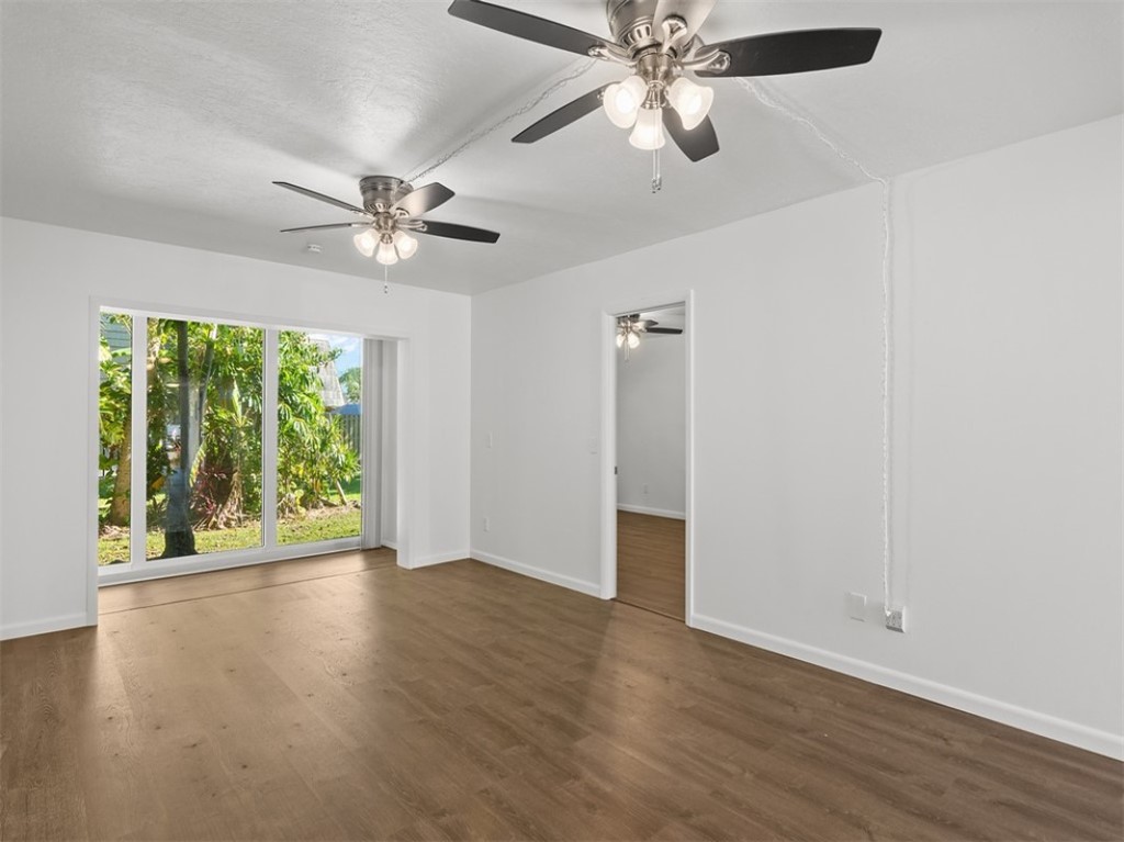 1166 6th Avenue, Unit C5 Vero Beach, FL 32960 - Photo 21 of 34 an empty room with wooden floor fan and windows