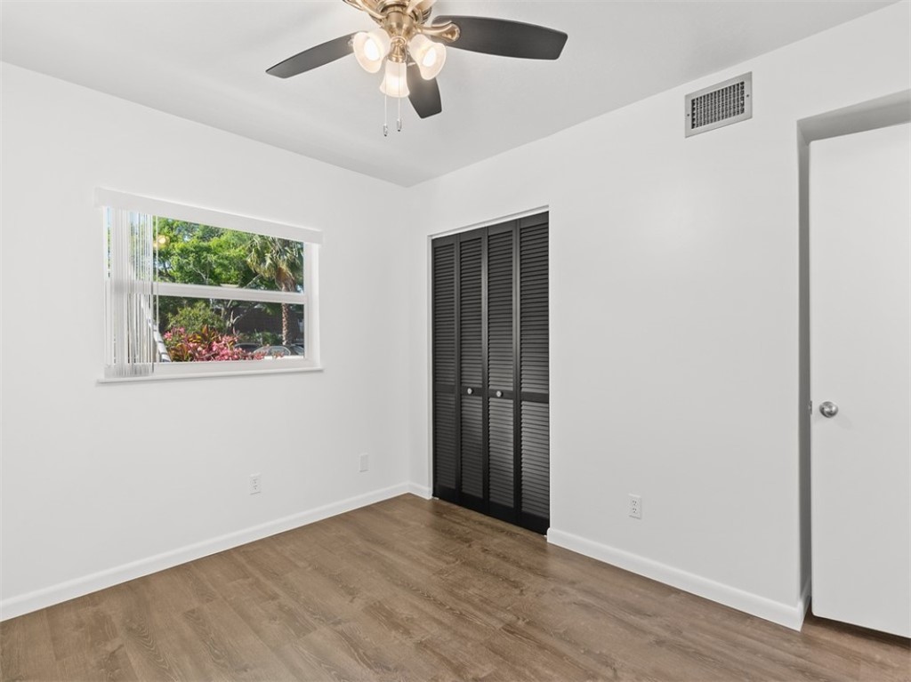 1166 6th Avenue, Unit C5 Vero Beach, FL 32960 - Photo 5 of 34 an empty room with wooden floor ceiling fan and windows