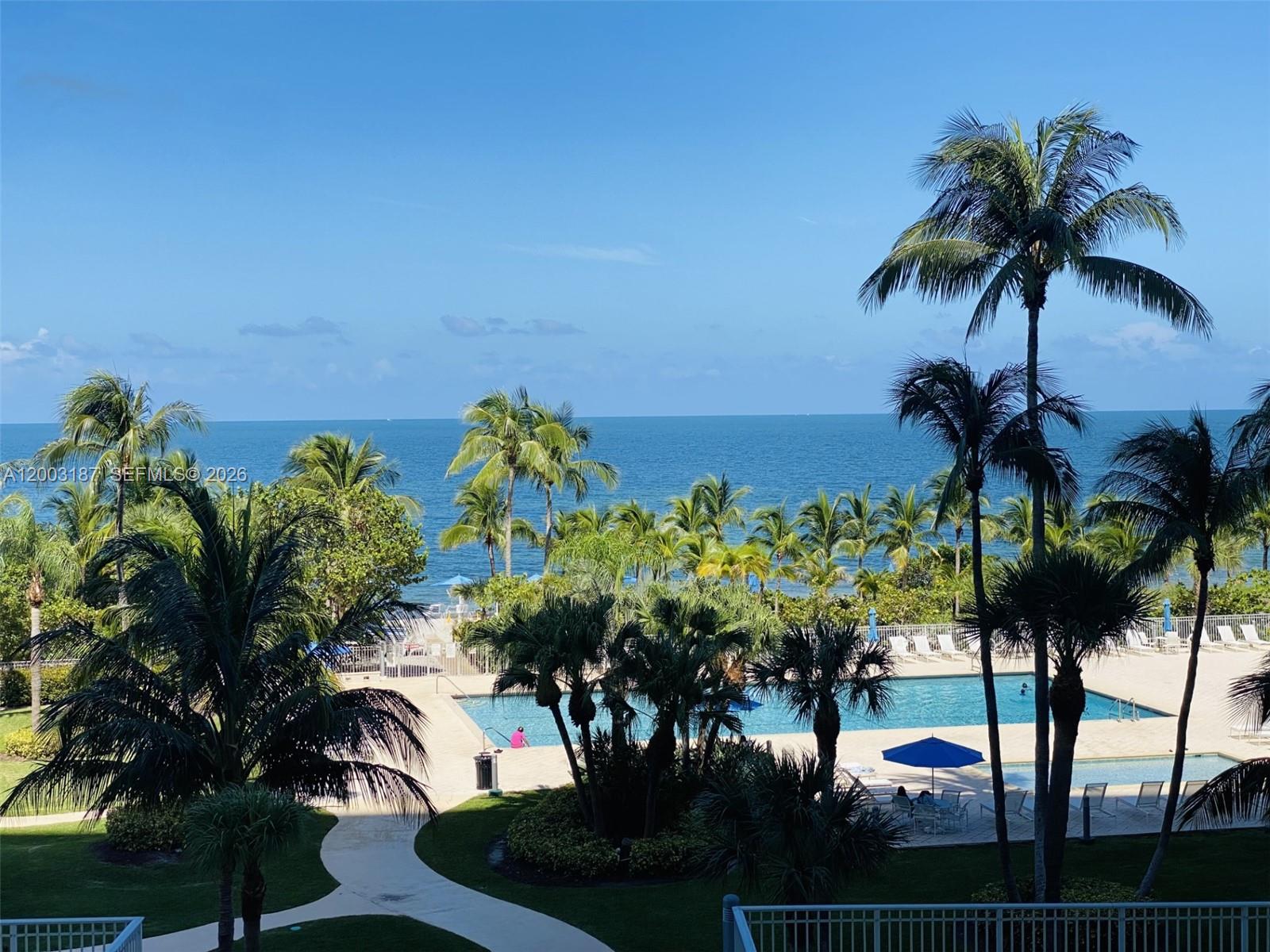 881 Ocean Drive, Unit 3E Key Biscayne, FL 33149 - Photo 2 of 15 a view of a palm tree with flower plants