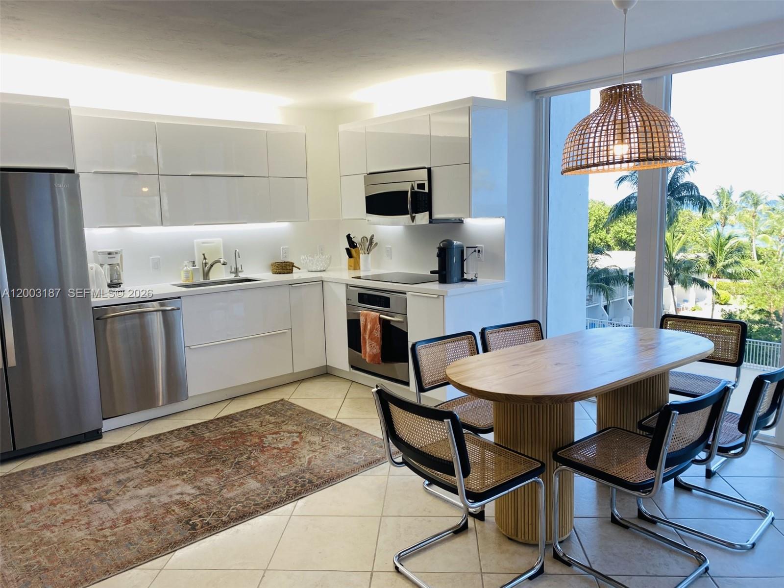 881 Ocean Drive, Unit 3E Key Biscayne, FL 33149 - Photo 6 of 15 a kitchen with stainless steel appliances a stove a table and chairs in it