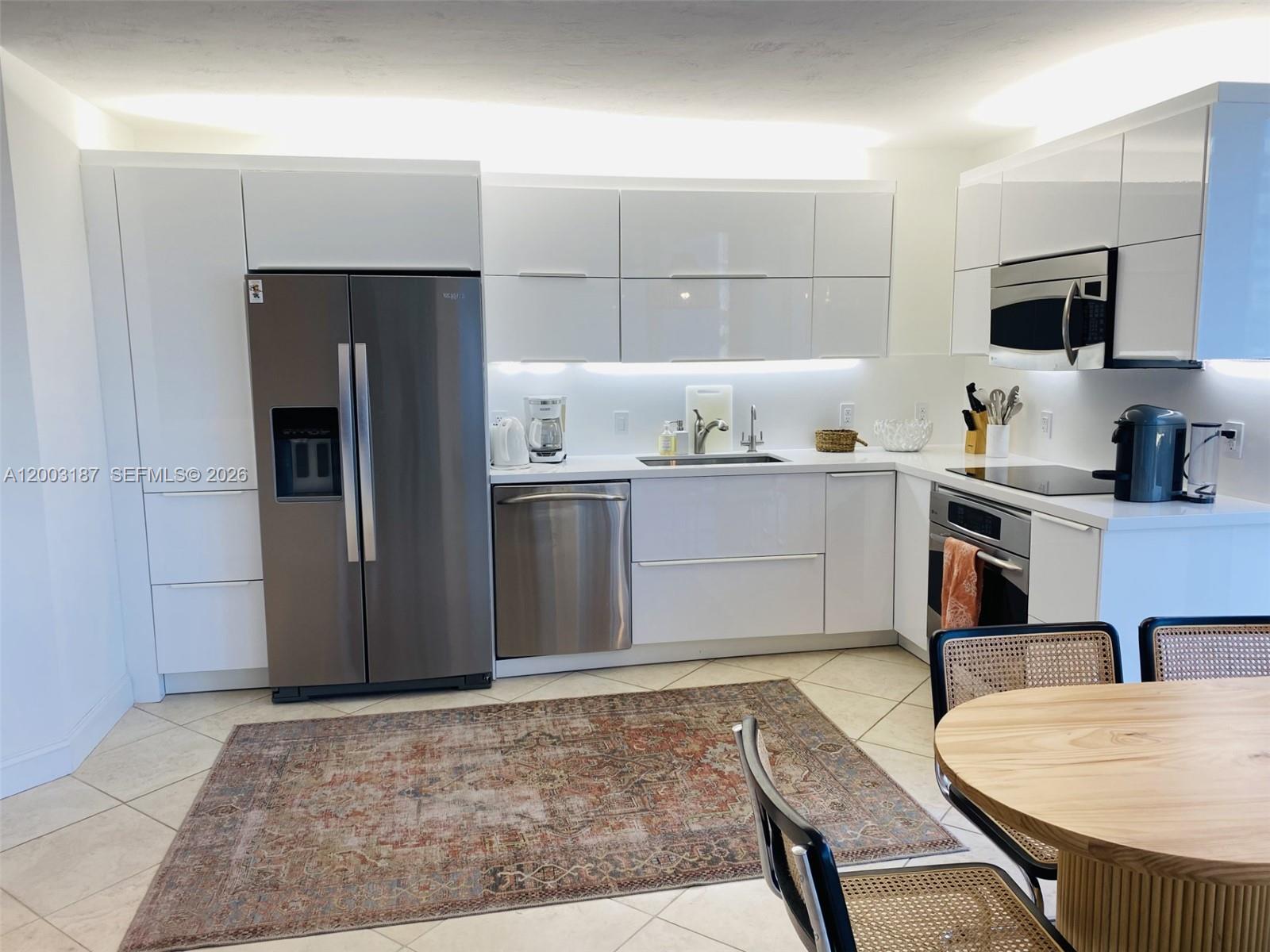 881 Ocean Drive, Unit 3E Key Biscayne, FL 33149 - Photo 9 of 15 a kitchen with stainless steel appliances granite countertop a sink stove refrigerator and cabinets