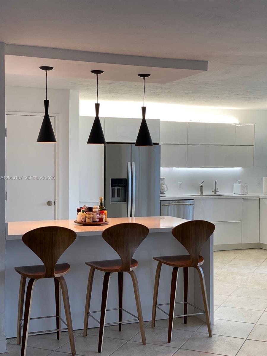 881 Ocean Drive, Unit 3E Key Biscayne, FL 33149 - Photo 10 of 15 a dinning table and chairs in a kitchen