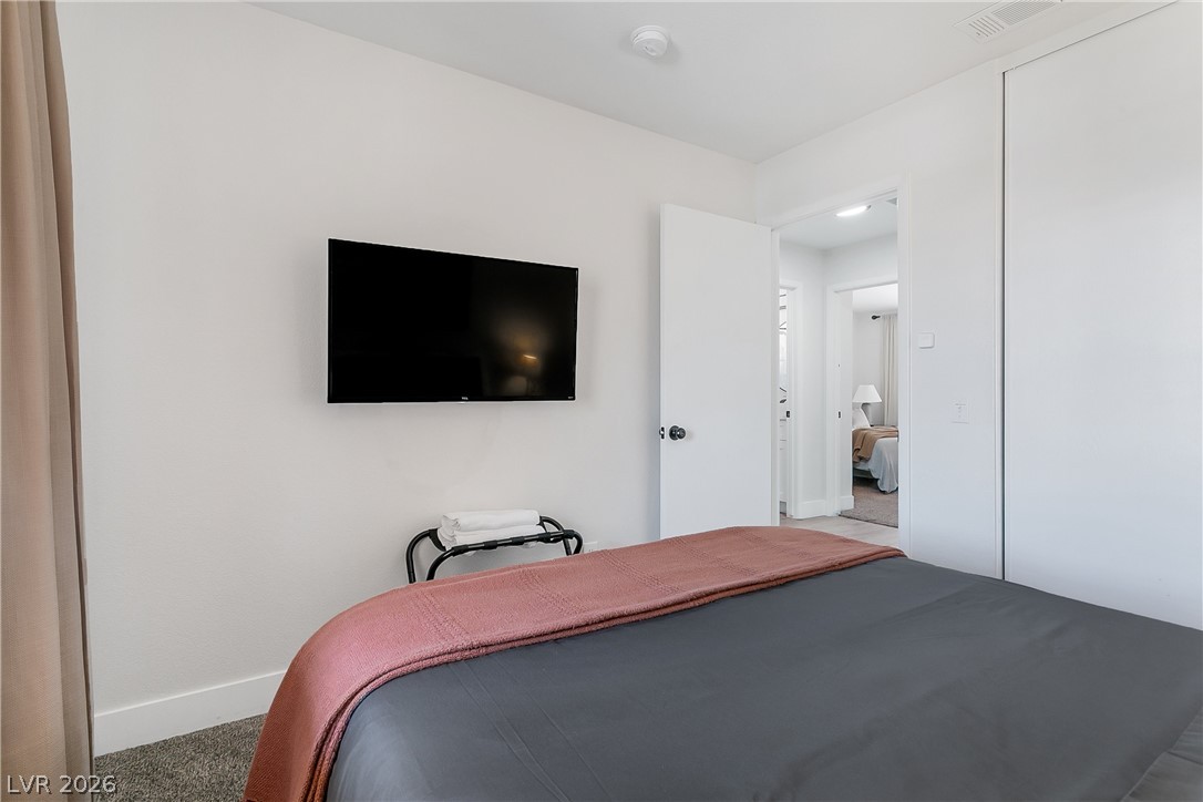 101 Beaver Ridge Avenue North Las Vegas, NV 89031 - Photo 25 of 42 A well-lit bedroom features plush carpeting and a doorway leading to another inviting space.