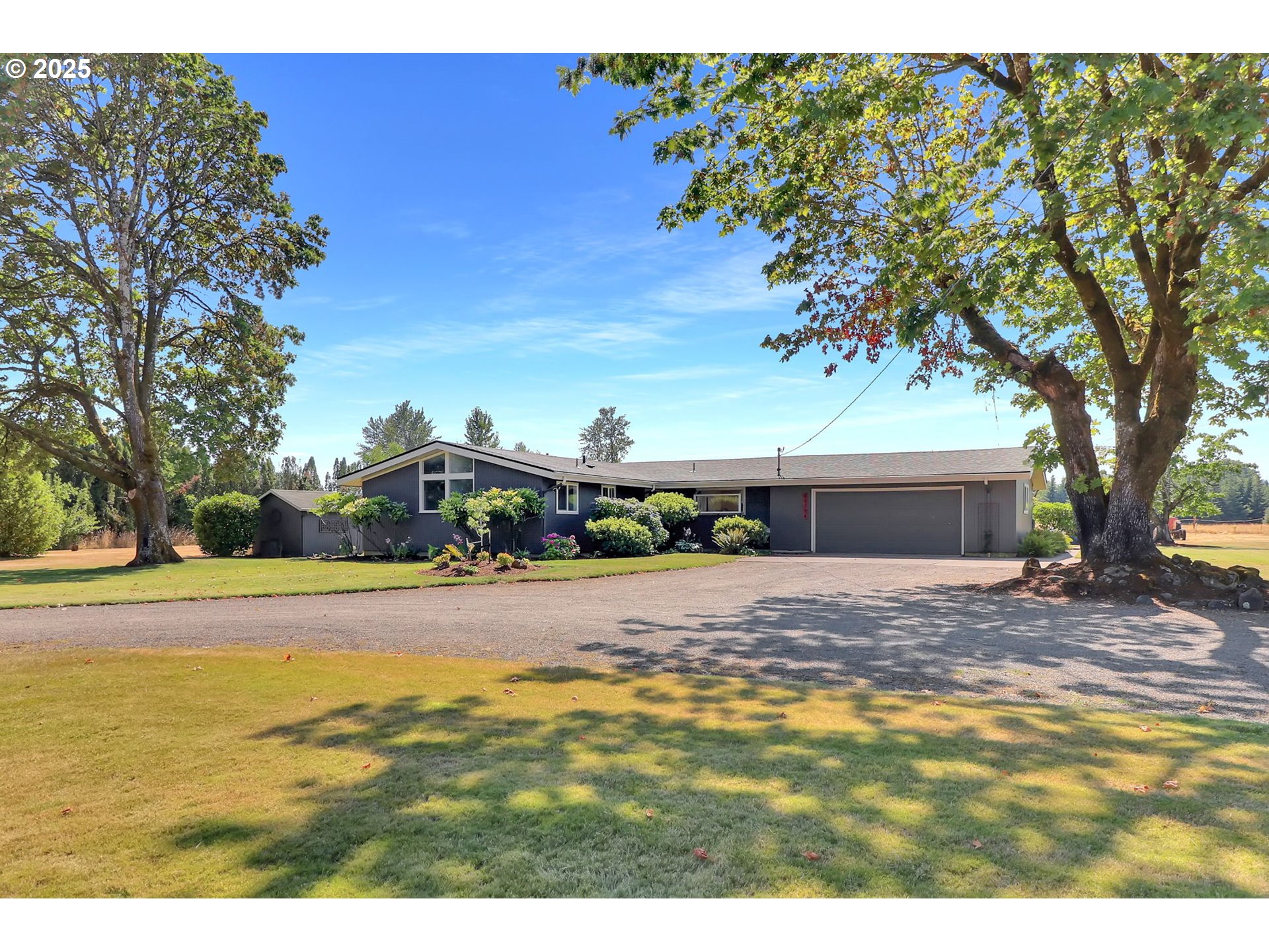 a view of an house with backyard and trees