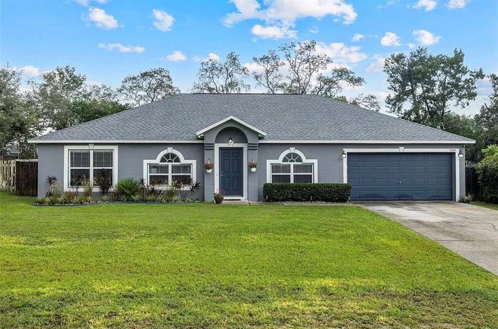 11102 Upton Street Spring Hill, FL 34608 - Photo 1 of 23 a front view of a house with a garden