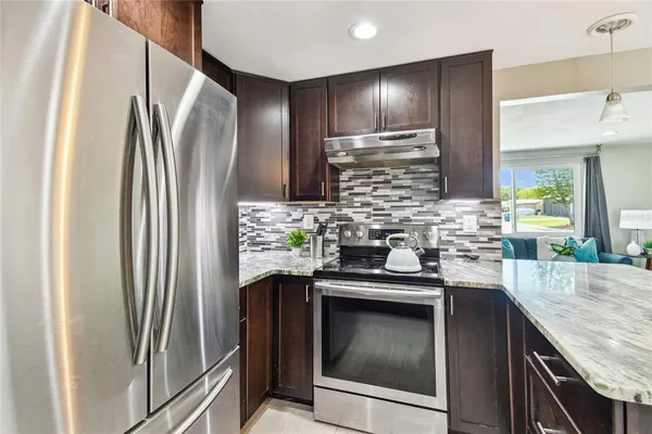 a kitchen with stainless steel appliances granite countertop a refrigerator and a sink