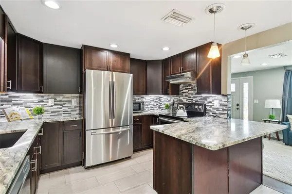 a kitchen with refrigerator and cabinets