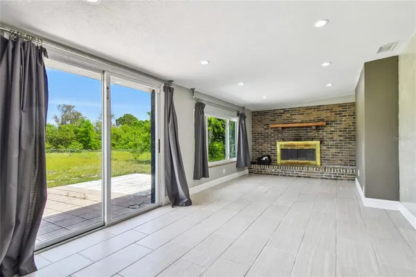 a view of an empty room with a fireplace and a window