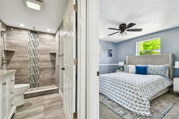 a bedroom with a large bed a chandelier and a window