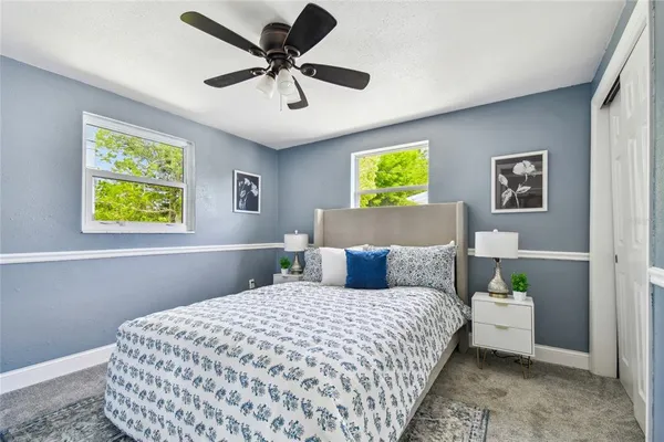 a bedroom with a bed chandelier and a window