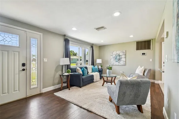 a living room with furniture and wooden floor