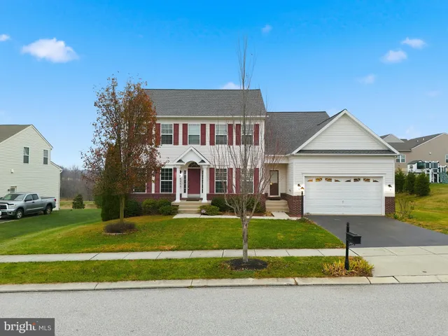 a view of a house next to a yard with big trees