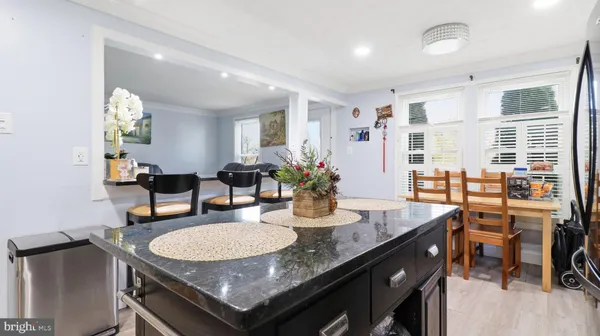 a kitchen with stainless steel appliances kitchen island granite countertop a stove refrigerator and cabinets