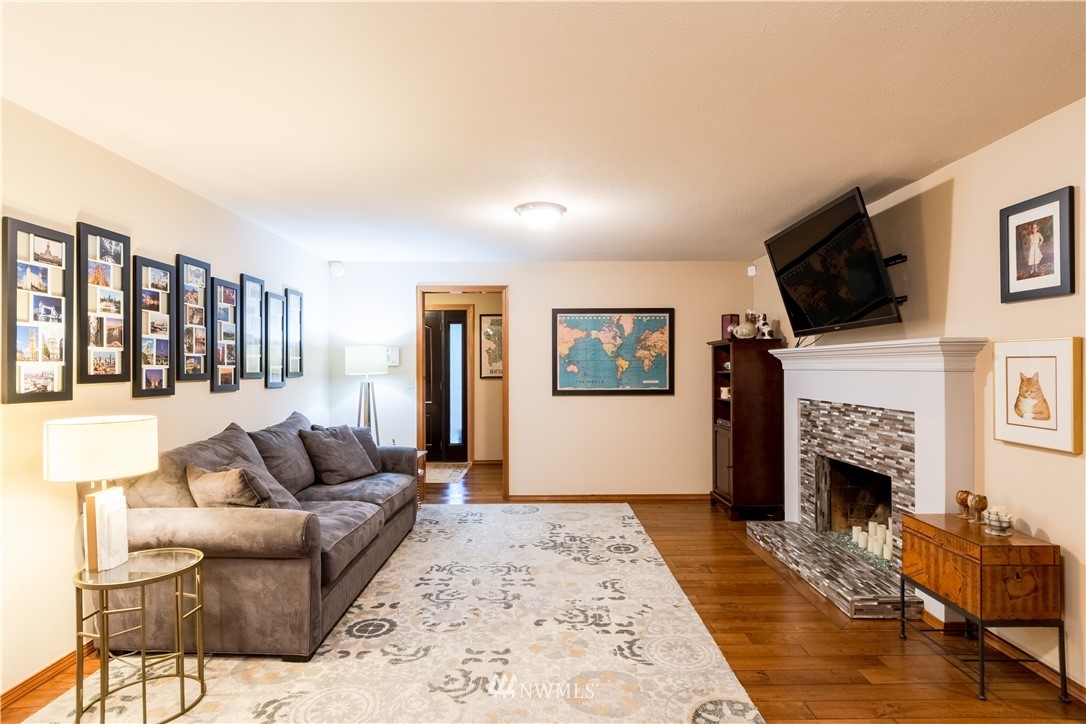 15543 Southeast 169th Street Renton, WA 98058 - Photo 11 of 35 a living room with furniture a flat screen tv and a fireplace