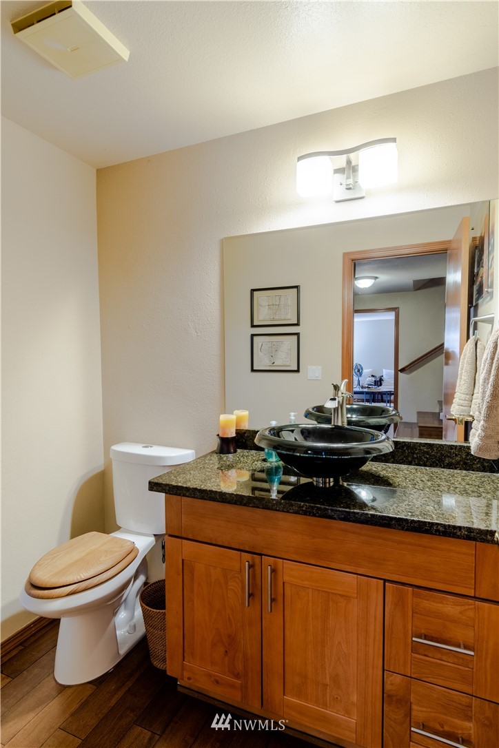 15543 Southeast 169th Street Renton, WA 98058 - Photo 13 of 35 a bathroom with a granite countertop toilet sink and mirror