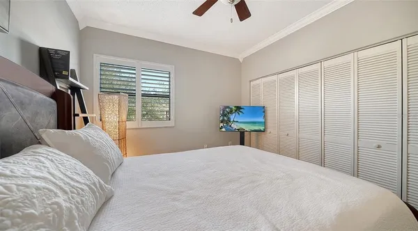 a bedroom with a bed and a flat tv screen on the dresser