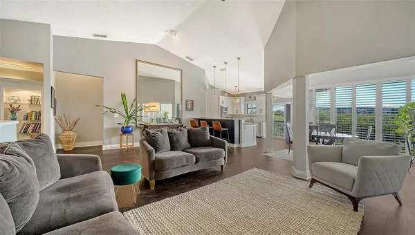 a living room with furniture white walls and a large window