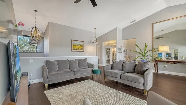 a living room with furniture and a wooden floor