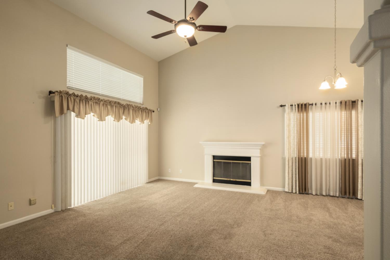 793 Applegate Avenue Clovis, CA 93611 - Photo 6 of 20 a view of an empty room with a fireplace and a window