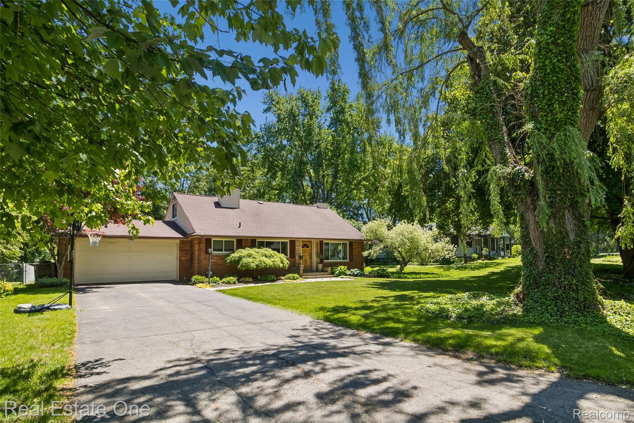 2189 Devonshire Road Bloomfield Hills, MI 48302 - Photo 45 of 50 Traditional brick residence featuring a two-car garage, mature landscaping, and an expansive front lawn