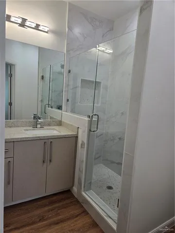 a bathroom with a shower sink vanity and mirror