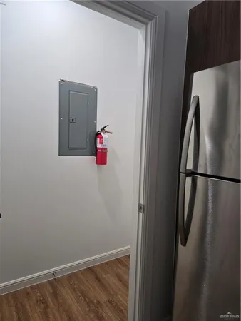 a bathroom with a refrigerator and wooden floor