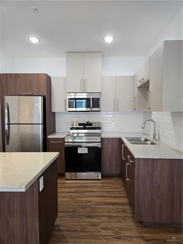 a kitchen with a sink appliances and cabinets