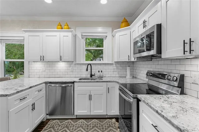 a bedroom with a large bed a chandelier and a window