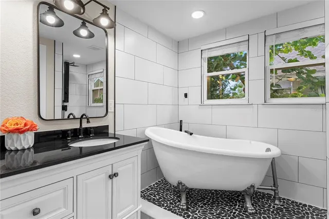 a bathroom with a granite countertop sink a toilet a mirror and shower