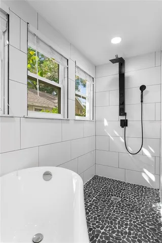 an empty room with windows and ceiling fan