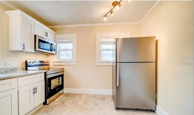 a patio with table and chairs and potted plants