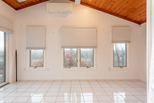 an empty room with windows and cabinet