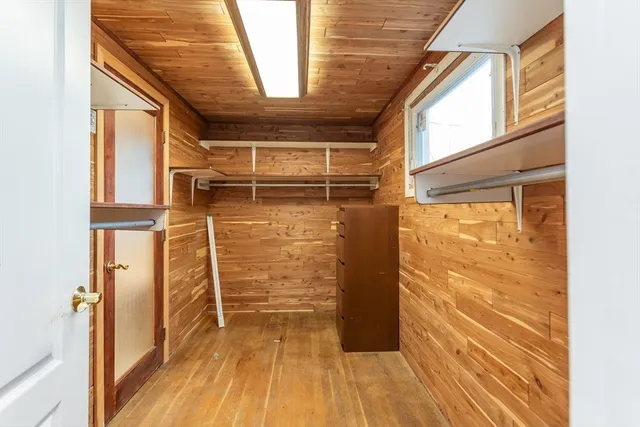 a view of walk in closet with wooden floor
