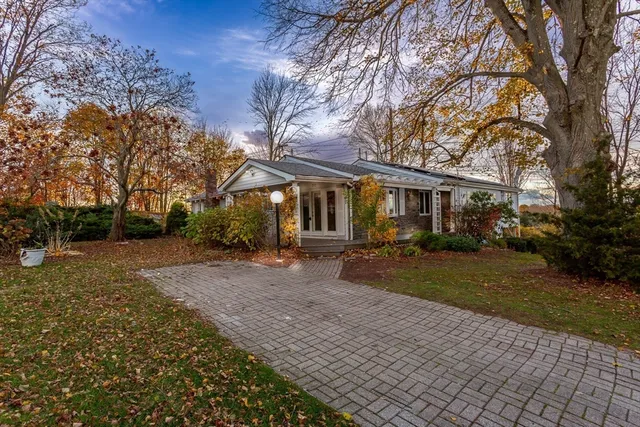 a front view of a house with a yard and trees