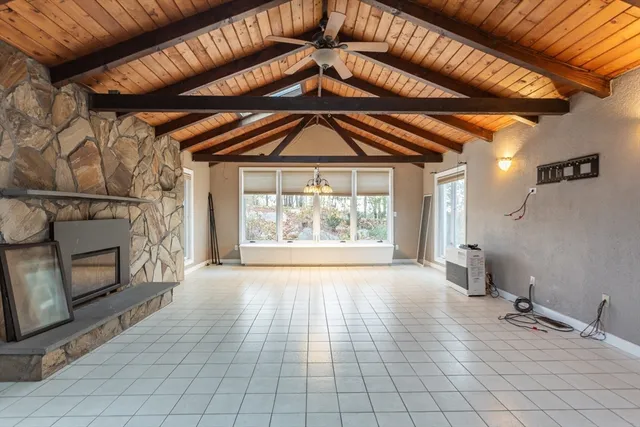 a view of an empty room with a fireplace and a window