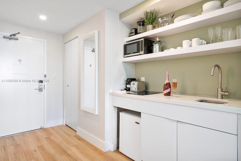 2889 McFarlane Road, Unit 1403 Miami, FL 33133 - Photo 5 of 17 a kitchen with a sink a refrigerator and cabinets
