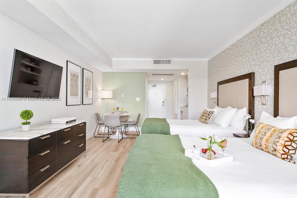 2889 McFarlane Road, Unit 1403 Miami, FL 33133 - Photo 6 of 17 a bedroom with a bed and a flat screen tv