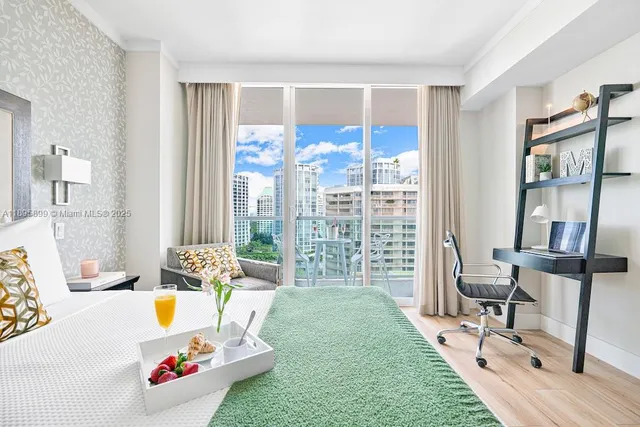 a spacious bedroom with a bed a table and a large window