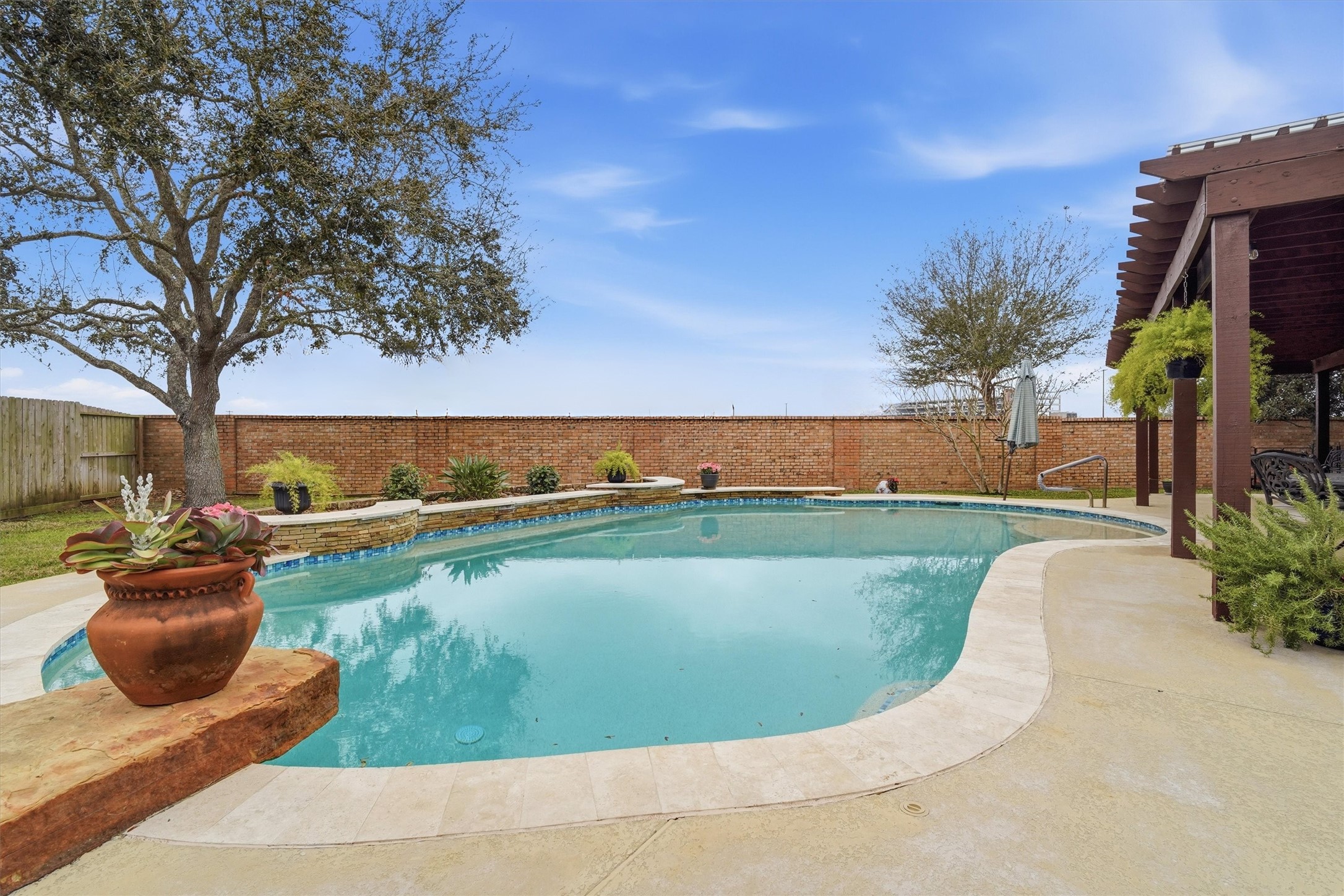 1558 Viejo Road League City, TX 77573 - Photo 26 of 28 Custom in-ground pool with curved design and raised stone planter accents.