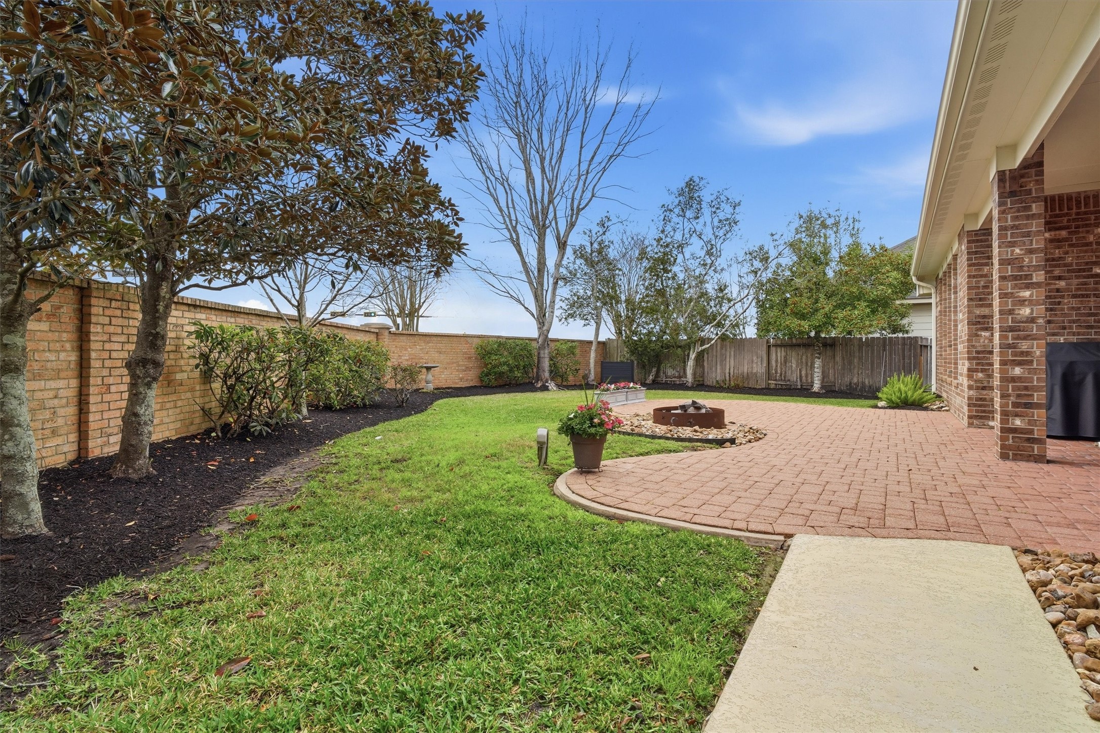 1558 Viejo Road League City, TX 77573 - Photo 28 of 28 Extended brick patio with fire pit area, additional seating space and spacious yard.