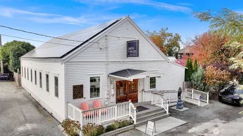 a view of a white house with large windows and couches