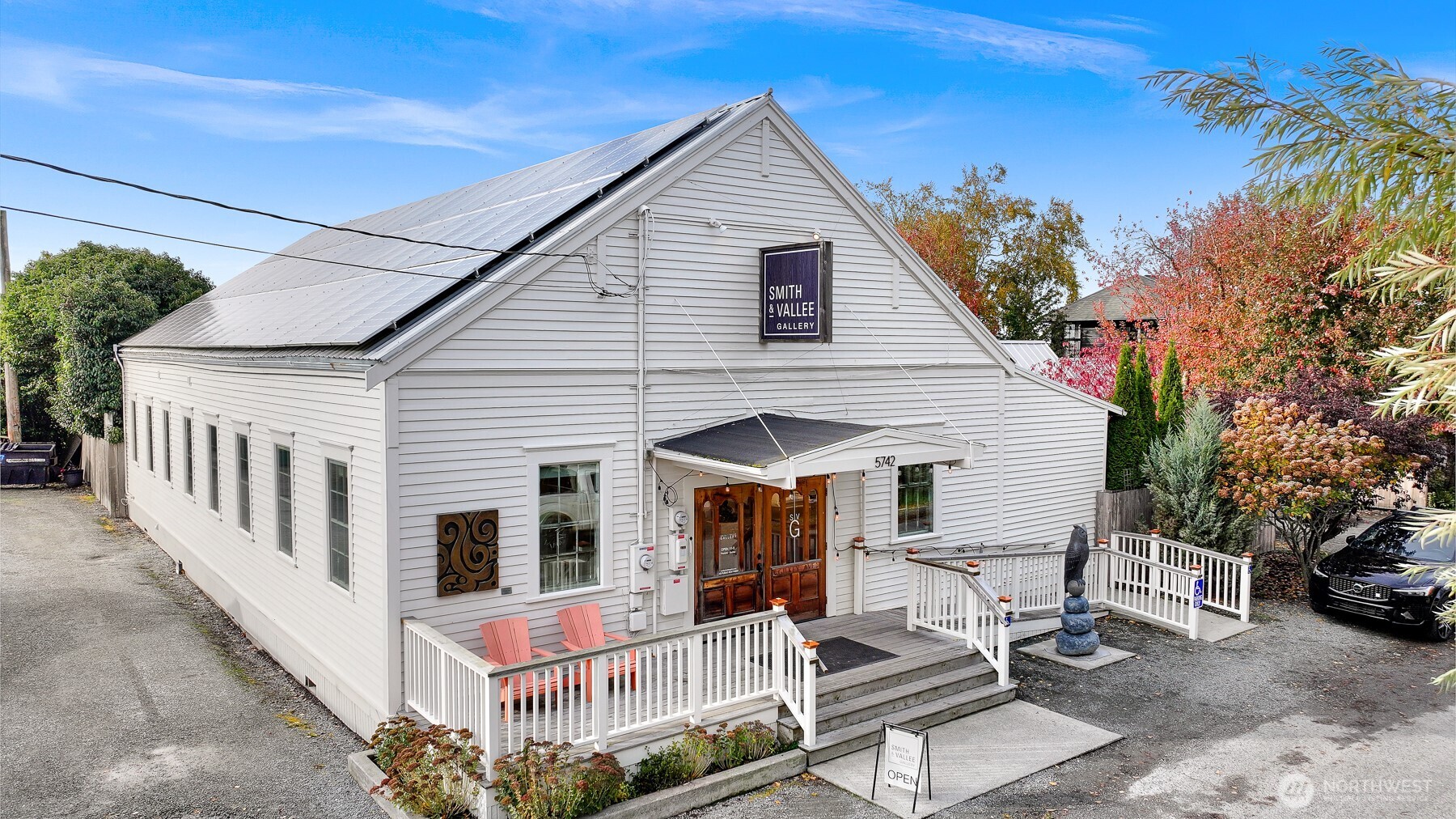 a view of a white house with large windows and couches