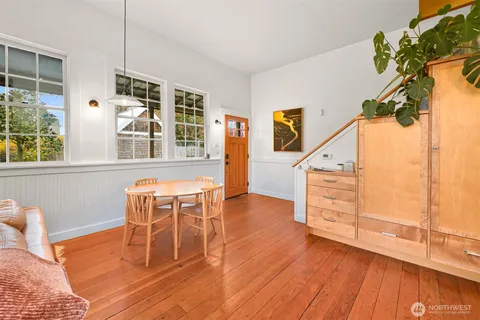 a dining room with wooden floor a glass table and chairs