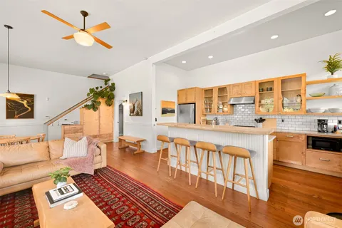 a very nice looking living room with a rug kitchen view and a large window
